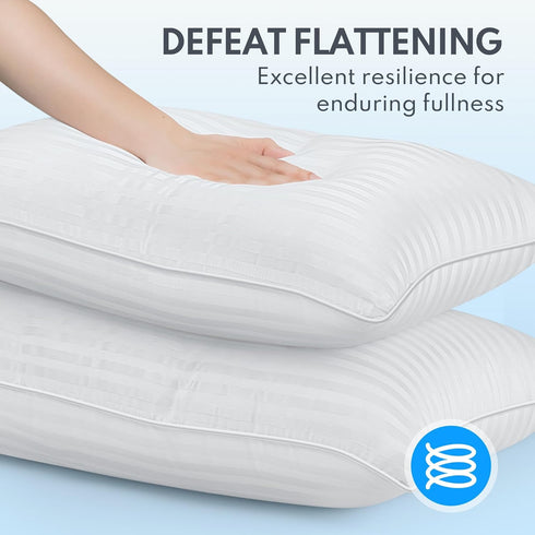 A pair of white, fluffy sleeping pillows with deep grooves, being touched by a hand to demonstrate their softness and texture. The image encourages touch and emphasizes comfort.